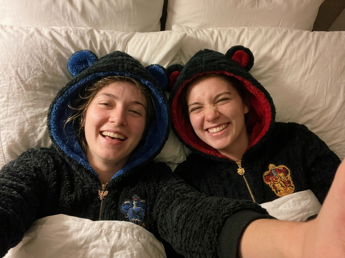Two friends taking a selfie in bed